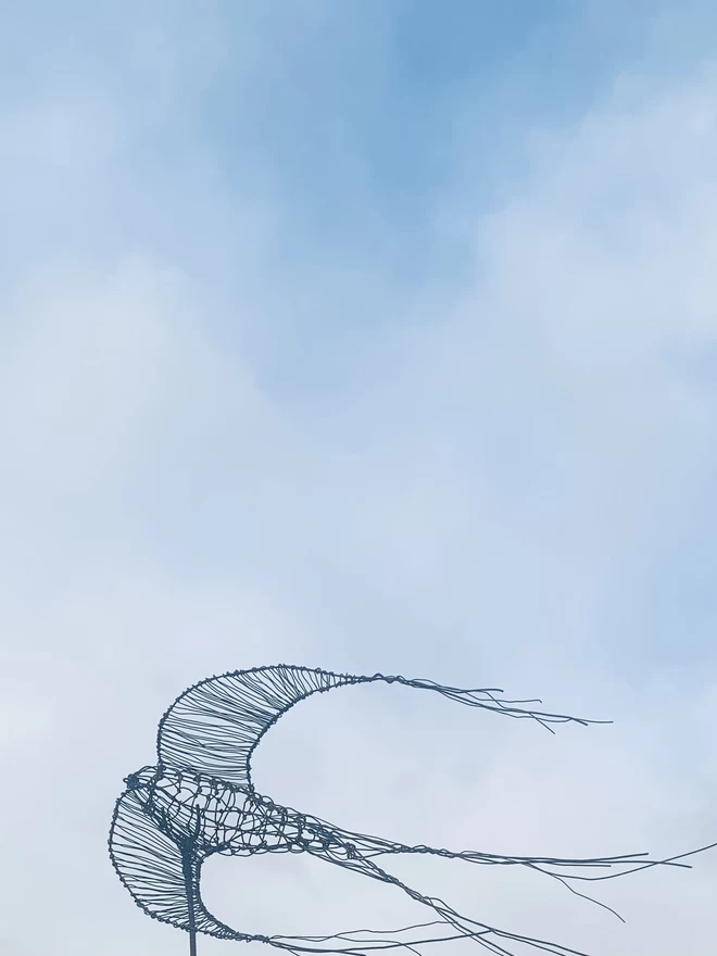 A 3 dimensional wire drawing of a swallow with exaggerated trailing wires on the wings and the tails to create an illusion of movement