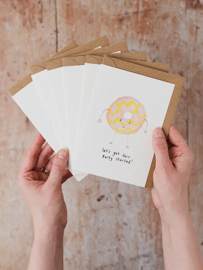 Hand holding 6 teatime treat cards including  a party ring 