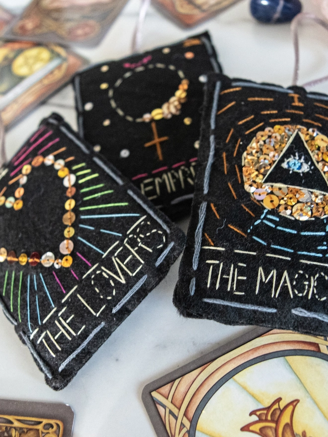 Handcrafted felt ornaments with sequins and embroidery depicting "The Magician”, “The Empress” and “The Lovers”