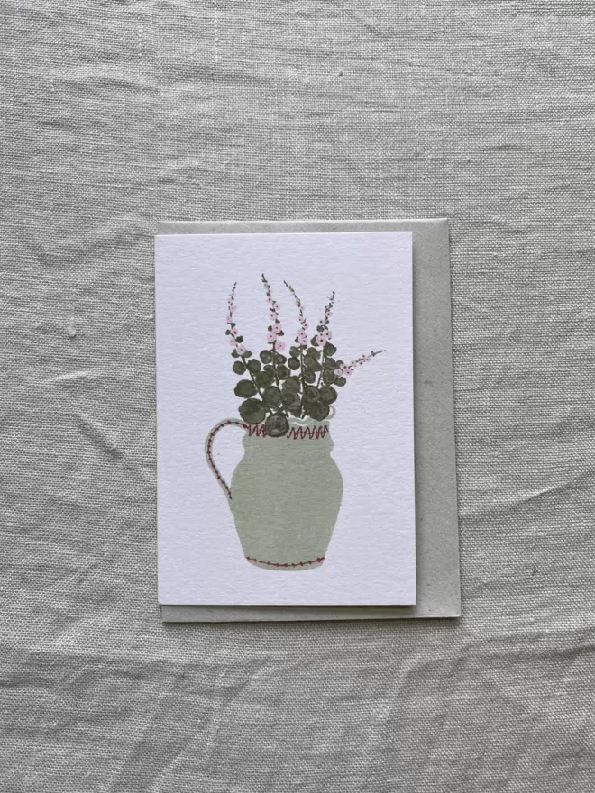 mini greetings card with cut hollyhocks on it arranged in a light green vase.