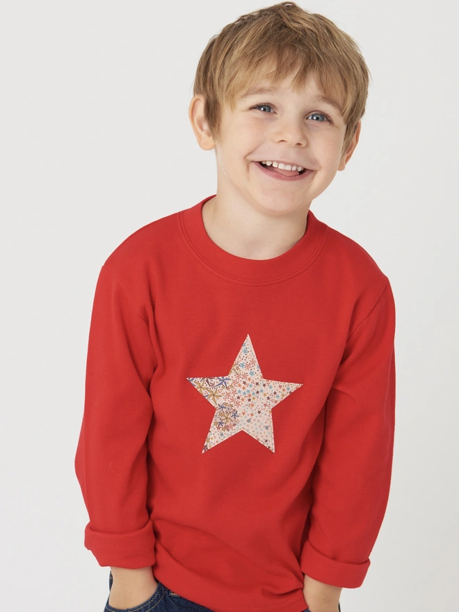 a 4 year old boy wearing a red tee with a christmas star cut from starry liberty print sewn onto the front