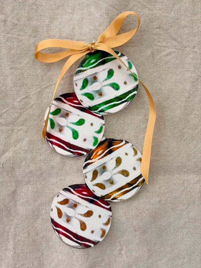 A set of four vintage bauble shaped cutouts on a linen tablecloth