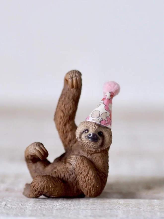 sloth with a pink party hat.