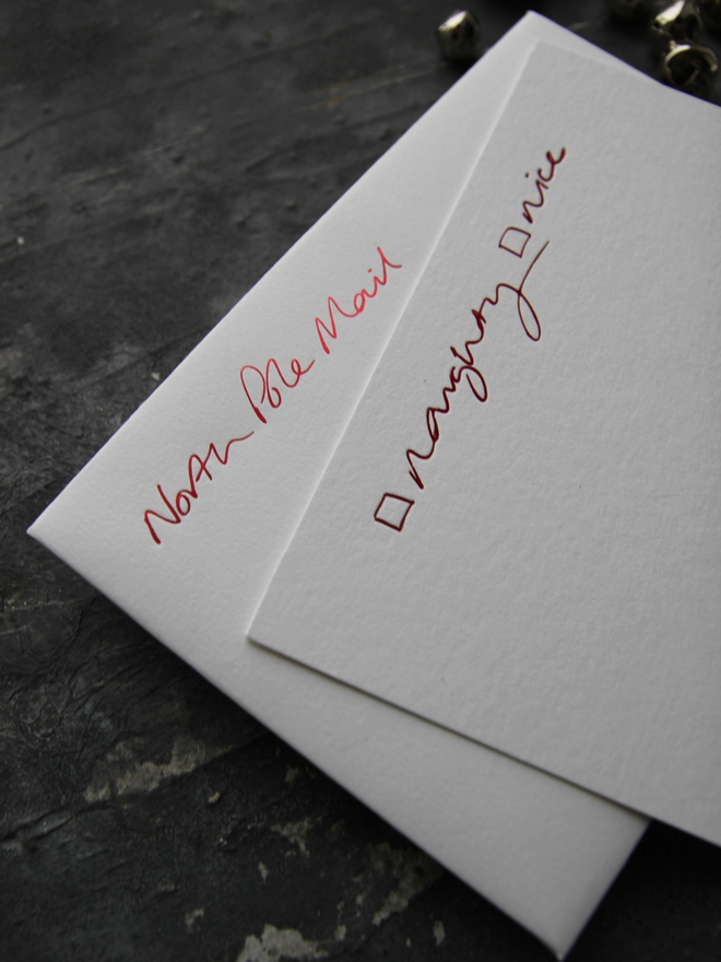 Christmas notecard from Santa that has a tick box for Naughty or Nice in red foil with an envelope that says North Pole Mail