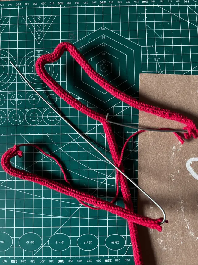 Partly made wire and string chilli Xmas tree topper on a green cutting mat