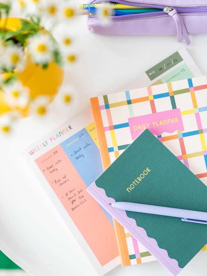 The A6 notebook duo sits on desk with other colourful stationery items from the Raspberry Blossom Happiness Stationery Collection