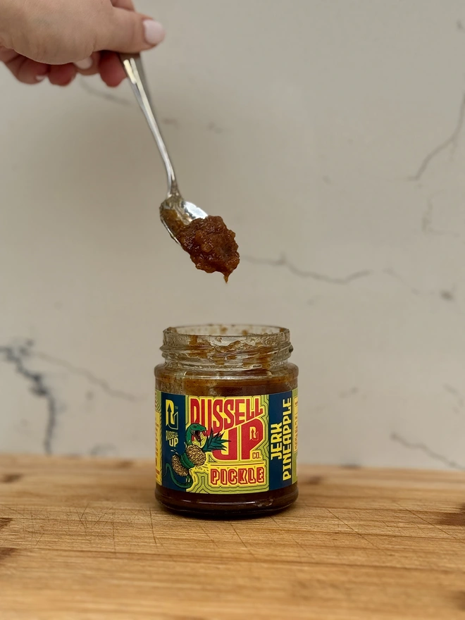 father's day pickles - spice set. a jar of jerk pineapple pickle being spooned out.