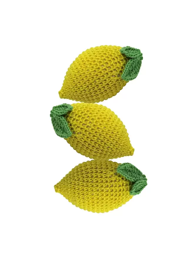 Three cut out crochet lemons balanced on top of each other.