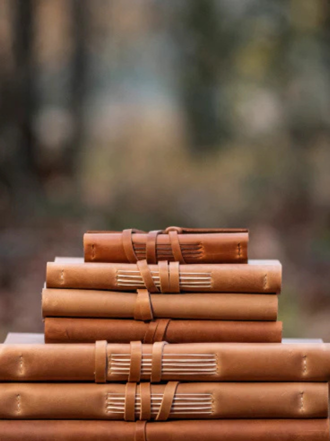 a5 medium leather journal. a stack light brown journals.