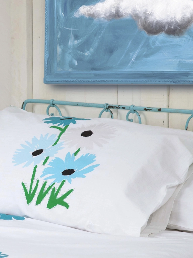 large cloud painting in turquoise painted directly onto a frame with a bed