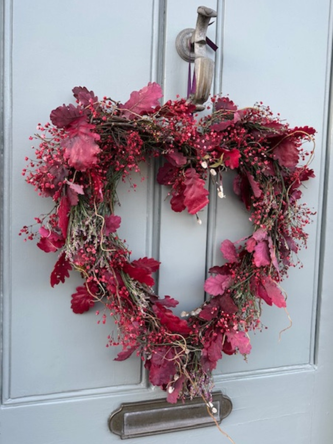 Dried Woodland Pink Heart Wreath hanging on a grey door