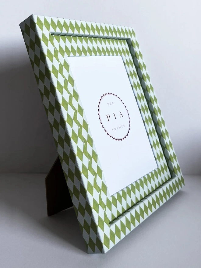 Chartreuse & Frost Harlequin Frame, a colourful patterned frame sitting on a plain white surface. 