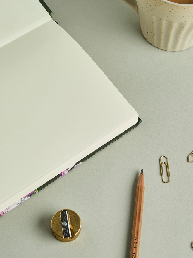 'Floral Brights' A5 Hardback Sketchbook. a sketchbook open to show blank pages, photographed on a plain grey background.