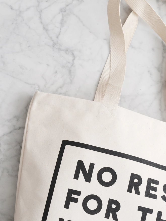 a close up of a large natural canvas tote bag bearing the words no rest for the with kid