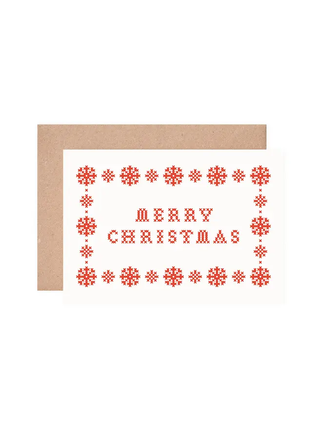 cutout of a christmas card screen printed with a cross stitch design
