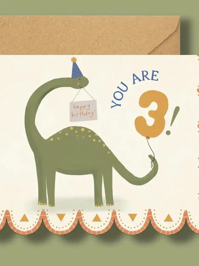 illustrated dinosaur 3rd birthday card. scallop edged birthday card illustrated with green stegosaurus.