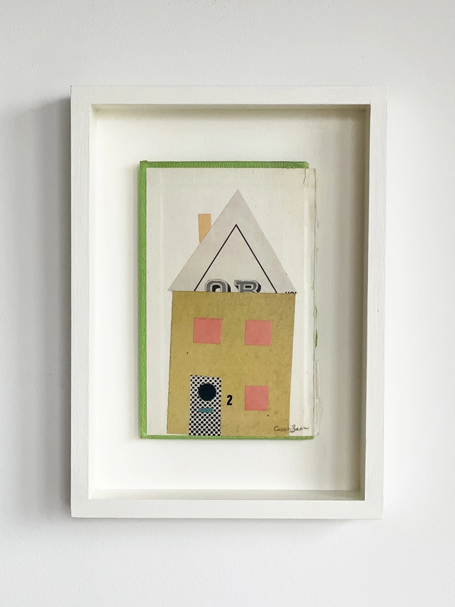 A house portrait made with vintage papers in mustard yellow and pink. Created on an old hardback book cover with green edges. Float mounted within a hand painted box frame.