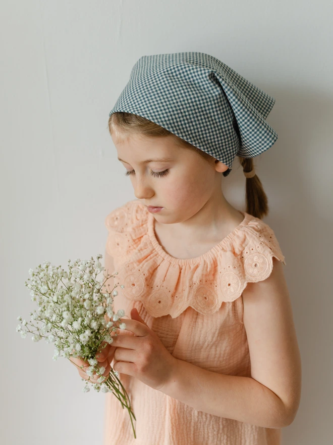 girl wearing her blue bandana holding flowers