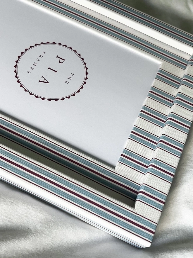 Sky & Scarlet Tailor Stripe Frame, a patterned colourful frame sitting on a plain white surface. 