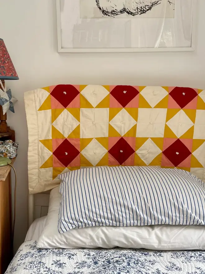 Warm Hearth Patchwork Quilt, on a bed. 