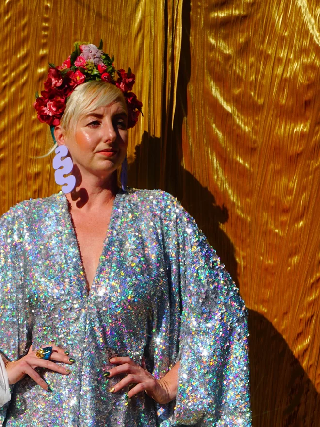 Silver Holographic Sequin V-neck Kaftan Gown seen with her arms on her side.