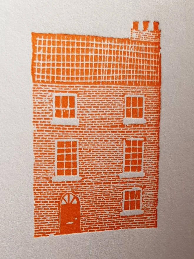 Orange Townhouse Letterpress Handprinted Greetings Card, a white card with an orange townhouse design in the centre. 