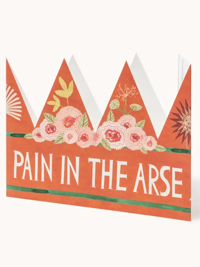 red crown shaped card with flowers and 'pain in the arse' text
