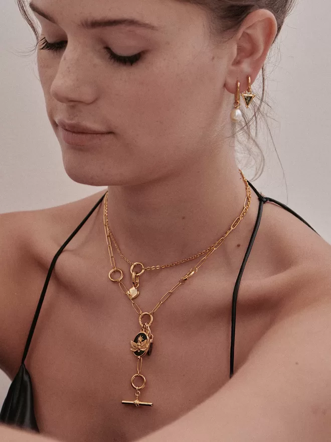 Woman wearing gold necklaces with charms and pendants