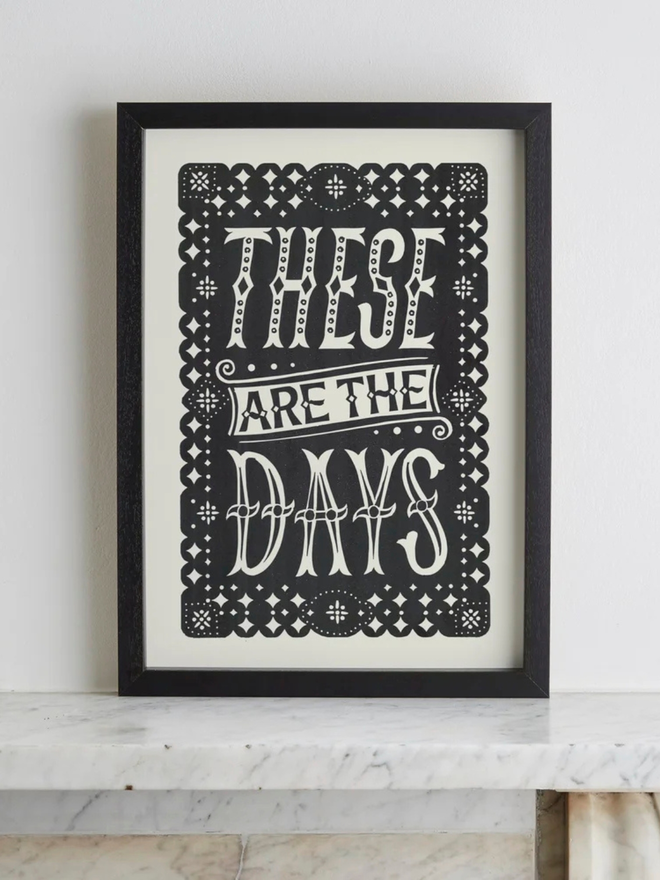 these are the days linocut. a linocut phrase printed on black paint.