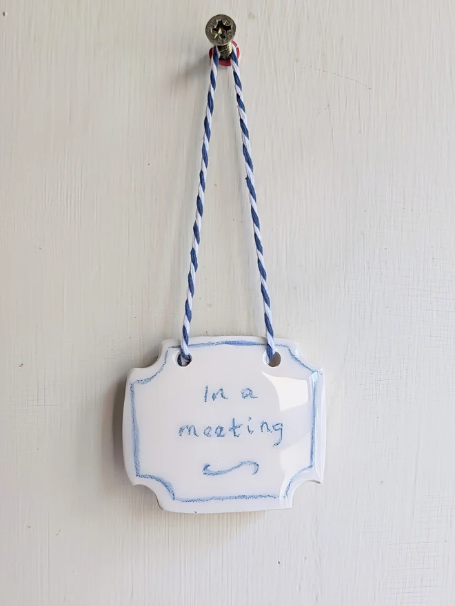 in a meeting blue and white ceramic sign