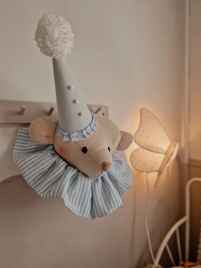 Bear Head Nursery Decoration, a bear decoration sitting against a wall in a child's decorated bedroom. 