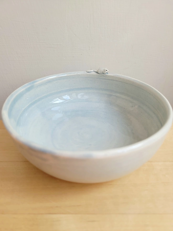 a grey pottery cat bowl with a tiny mouse on the edge rim