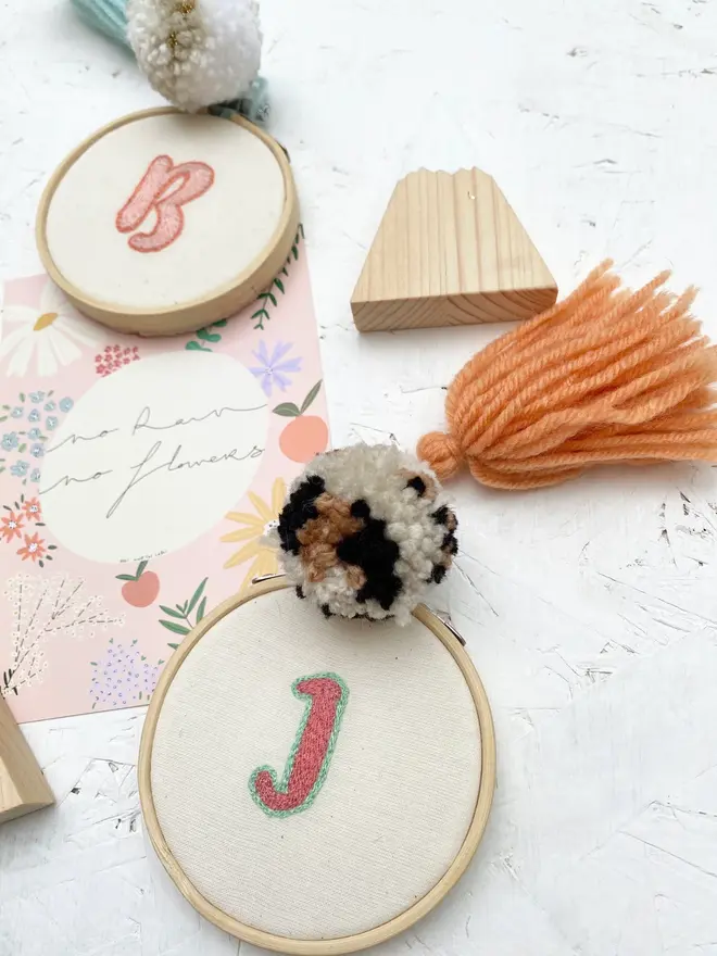 custom letter or number embroidered hoop. selection of cotton hoops embroidered with various letters and numbers in a variety of colours.