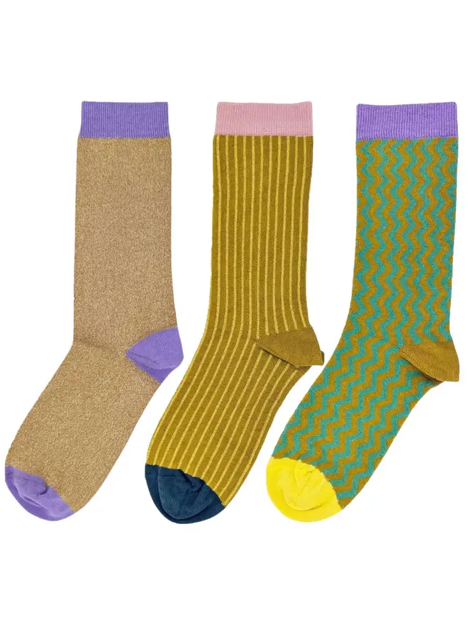 Women's Organic Cotton Ankle Socks Packs (Sets Of 3), a pack of three colourful patterned socks sitting on a plain white surface. 