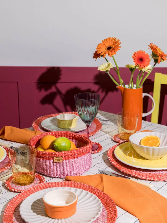 table set up featuring red and pink woven tableware