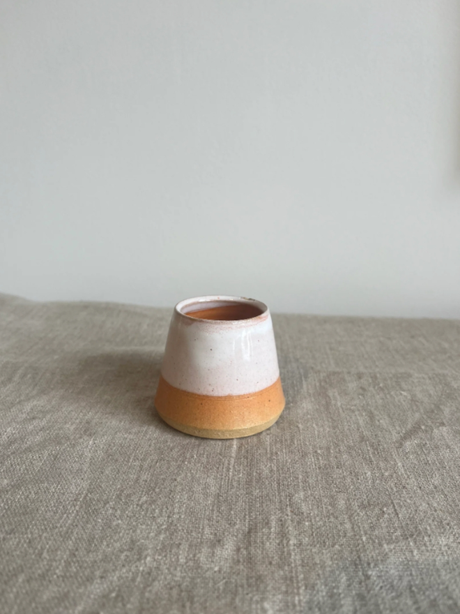 Egg Cup. An orange egg cup. The bottom ring of the cup is a darker and more vibrant orange.