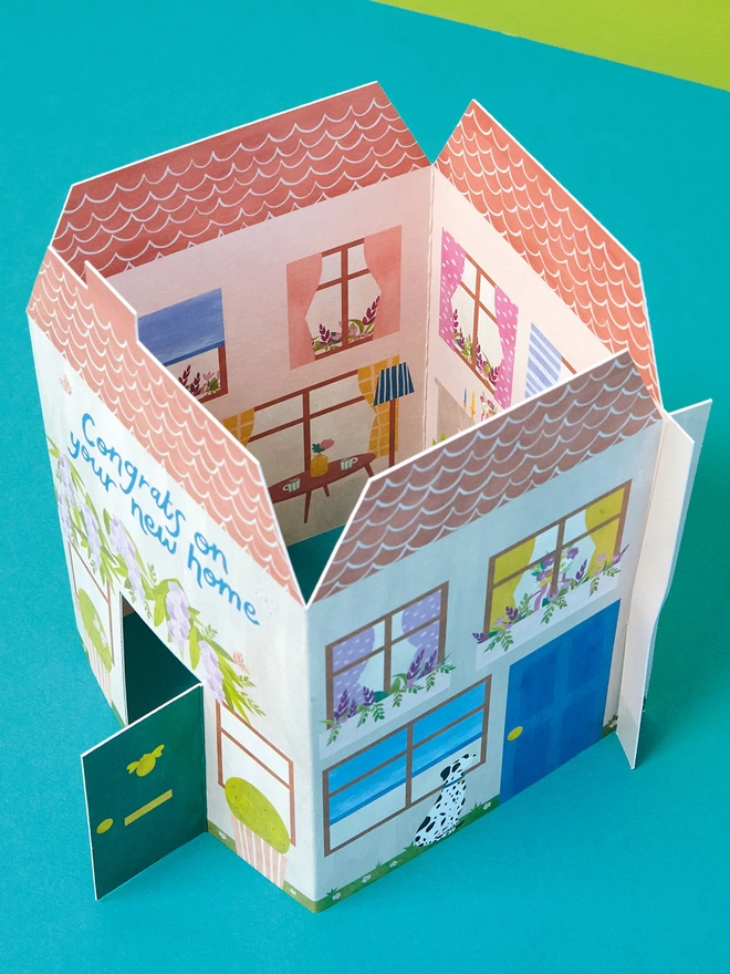 above view of 3D fold-out new home card, shows beautifully painted intricate details of the house interior, and die cut front door of house that opens out