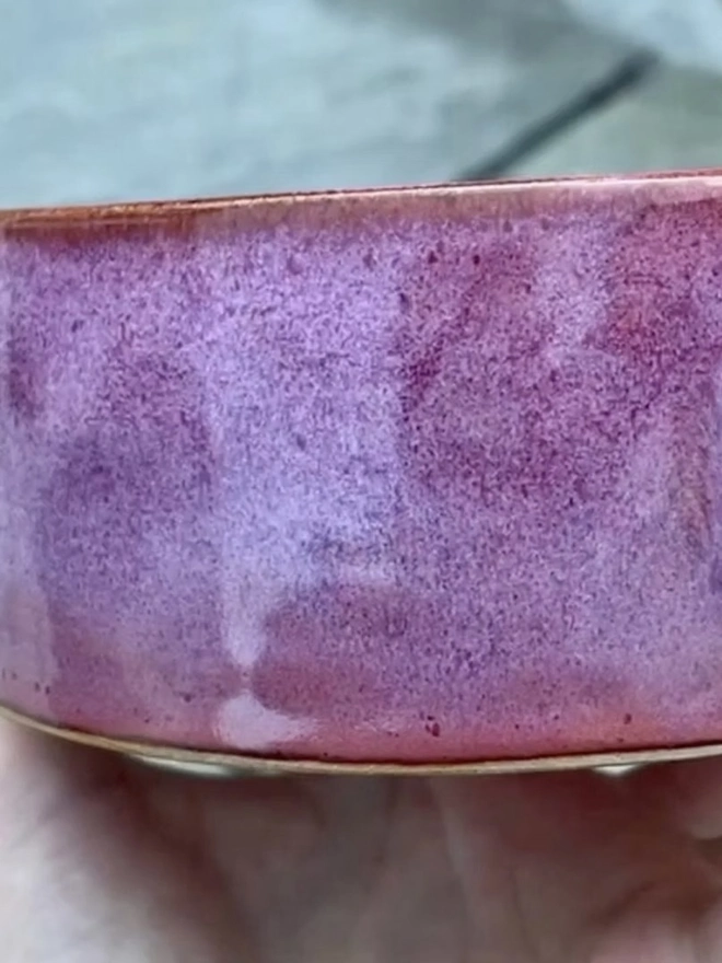 Personalised Handmade Ceramic Cat And Dog Bowls, pink pet bowl on a wooden surface. 