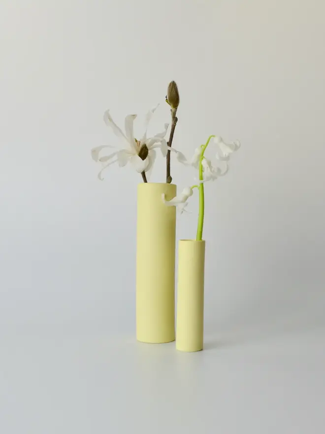 2 yellow stem vases with flowers