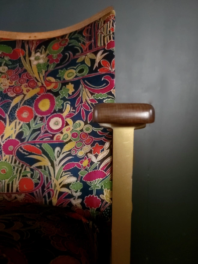 Close up of vintage cinema seat leg and armrest with floral velvet