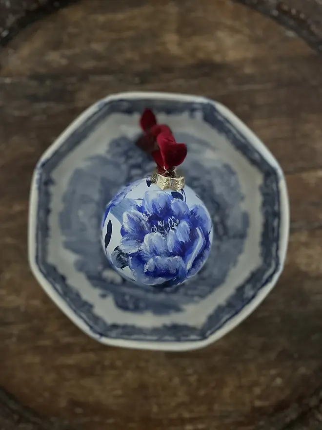 hand painted ceramic toile de jouy inspired Christmas bauble rich blues featuring delicate peony flowers 
