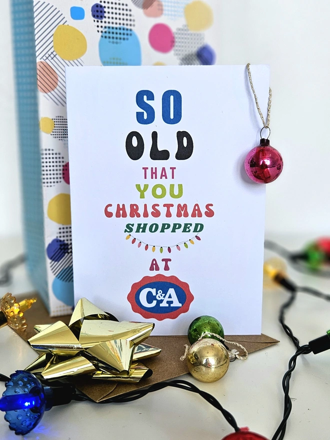 A photograph of the front of a humorous A6 greeting card illustrated using brightly coloured text and the retro shop logo. The text says so old you Christmas shopped at C&A
