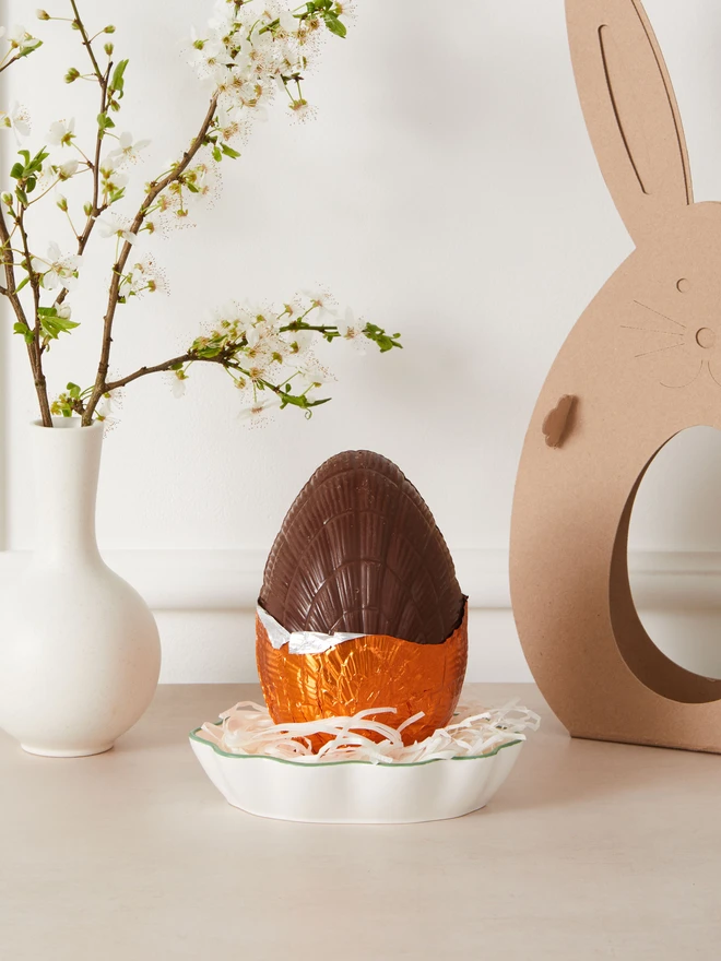 orange milk chocolate easter egg. a chocolate egg photographed partially unwrapped from orange foil