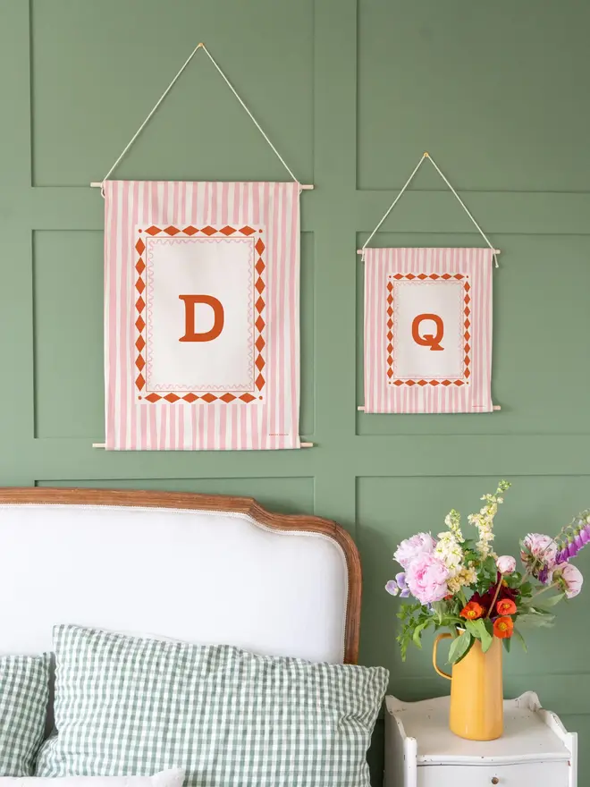 Stripe Initial Fabric Banner, hanging on a green wall. 