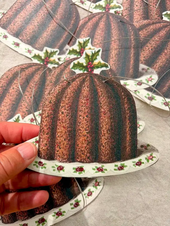 A set of nine paper cut out Christmas puddings strung as bunting