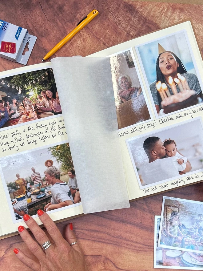 an a4 photo album has been filled with photos and messages of family and friends and lies open on a coffee table.