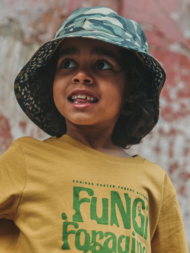 Boy wearing sun bucket hat in camo print