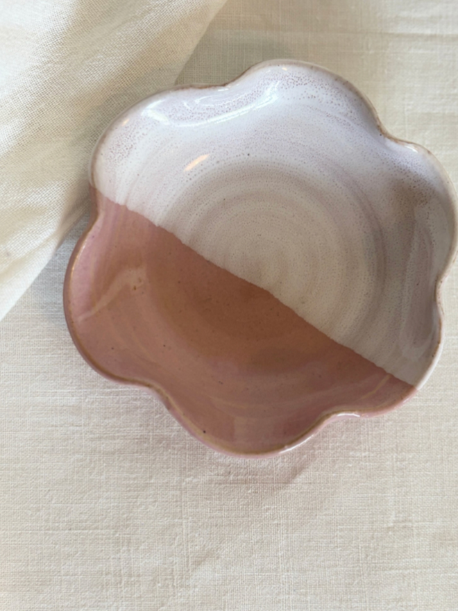Mini Frilly Dish. A half pink and half white dish with wide frills lays on a piece of light cloth.