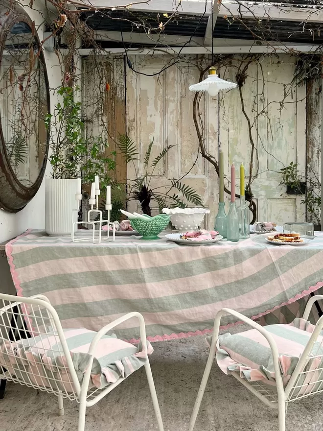 Ruffle Cushion in 'Gelato' on white chairs outside by a table
