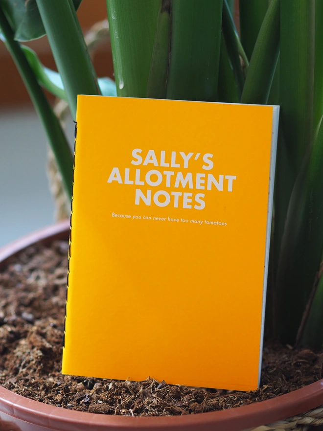personalised allotment notebook. a yellow coloured notebook personalised with a name and allotment notes. followed by because you can never have too many tomatoes.